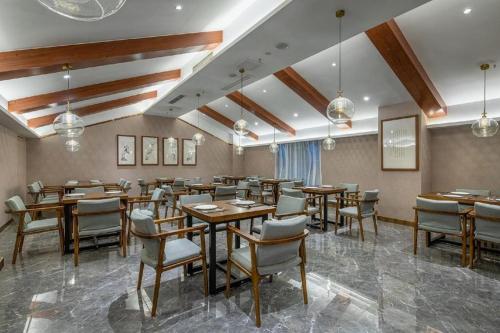 重慶的住宿－Xiangsu Boang Hotel，用餐室配有木桌和椅子