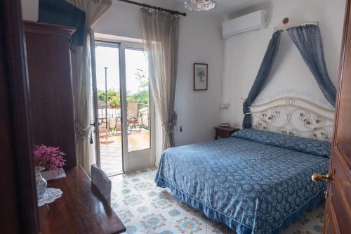 Schlafzimmer mit einem Bett mit blauer Tagesdecke in der Unterkunft Nido Degli Dei in Agerola