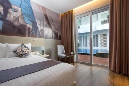 una camera d'albergo con un letto e una grande finestra di Horison Hotel Ultima Timika a Timika