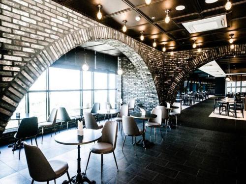 a restaurant with tables and chairs and a brick wall at Grand Hillstone in Jeonju