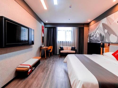 um quarto de hotel com uma cama e uma televisão de ecrã plano em Thank Inn Guizhou Bijie Qianxi County High-Speed Railway Station em Qianxi