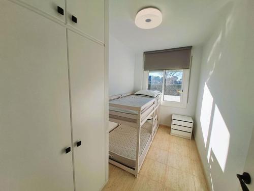 Habitación pequeña con cama y ventana en Apartamento 1a línea de mar, en Empuriabrava