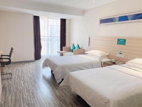 a hotel room with two beds and a couch at City Comfort Inn Wuhan South Lake Zhongnan University of Economics and Law Fashion City in Liufangling