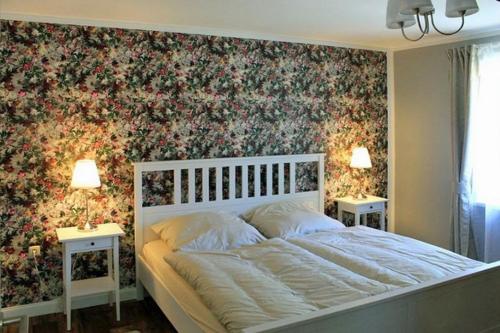 a bedroom with a bed with a floral wallpaper at Ferienwohnung Irisgarten am Pfarrgarten Starkow in Velgast