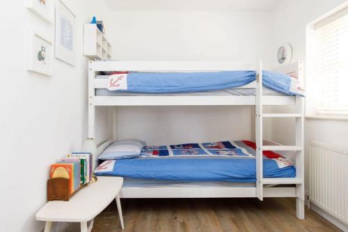 a bedroom with two bunk beds and a desk at 3bd Family Beach Retreat in West Wittering in West Wittering