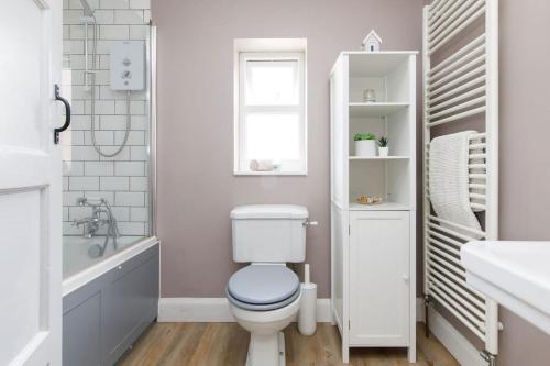a bathroom with a toilet and a tub and a sink at 3bd Family Beach Retreat in West Wittering in West Wittering