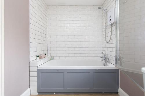 a white bathroom with a tub and a sink at 3bd Family Beach Retreat in West Wittering in West Wittering