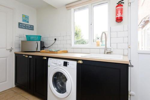 a kitchen with a washing machine and a sink at 3bd Family Beach Retreat in West Wittering in West Wittering
