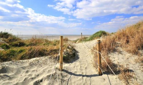 a fence in the sand on a beach at 3bd Family Beach Retreat in West Wittering in West Wittering