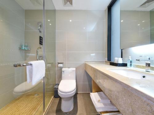 W łazience znajduje się toaleta, umywalka i lustro. w obiekcie City Comfort Inn Hantianhe Airport Hengdian Street w mieście Huangpi