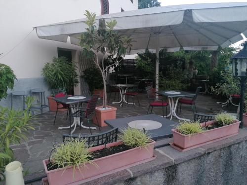 a patio with tables and chairs under an umbrella at Garni Brunnenhof in Caldaro