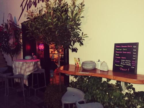 a restaurant with a table with plants and a chalkboard at Garni Brunnenhof in Caldaro