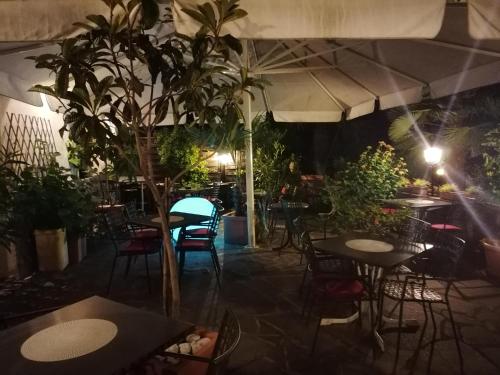 a restaurant with tables and chairs and plants at Garni Brunnenhof in Caldaro