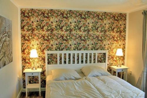 a bedroom with a bed with a floral wallpaper at Ferienwohnung Rosengarten am Pfarrgarten Starkow in Velgast