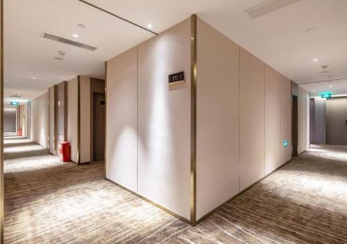un corridoio di un ufficio con una fila di ascensori di Premier City Comfort Hotel Quanzhou Wanda Plaza a Donghai