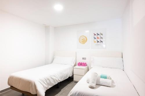 two beds in a room with white walls at Luminoso Apartamento en La Tejita in Granadilla de Abona