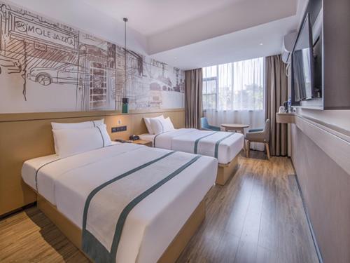 a hotel room with two beds and a tv at City Comfort Inn Wuzhou Sanqi City Rose Lake Park in Wuzhou