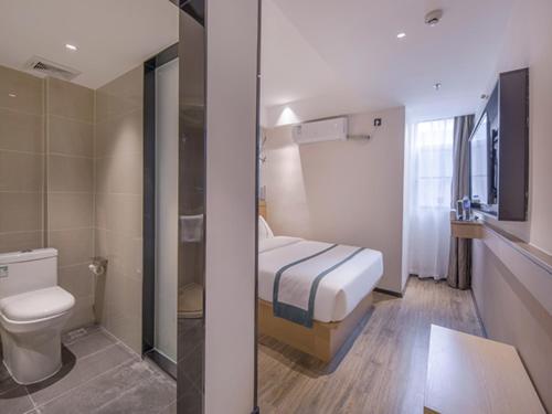 a small bathroom with a bed and a toilet at City Comfort Inn Wuzhou Sanqi City Rose Lake Park in Wuzhou