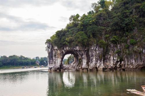 an arch in a rock formation in the water at Borrman Hotel Guilin Elephant Hill Park Li Lake in Guilin