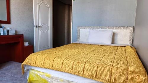 sypialnia z łóżkiem z żółtym kocem w obiekcie Hayan Sung Motel w Pusanie