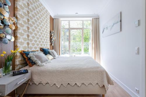 a bedroom with a large bed with a window at Jogailos Residence peaceful Old Town luxury 3 bdr, 2 bthr, FREE GARAGE, top-speed WIFI in Vilnius