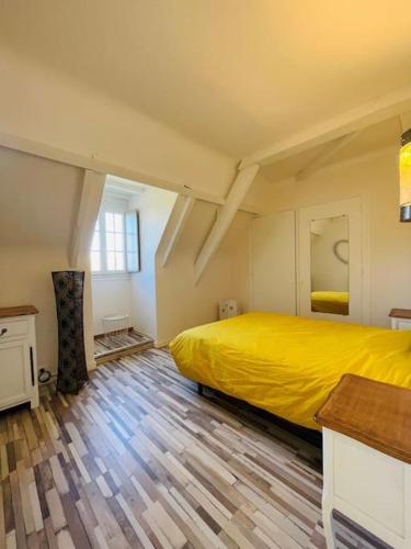 - une chambre avec un lit jaune et du parquet dans l'établissement Villa La Canéda*Spacieuse*Piscine*Sarlat, à Sarlat-la-Canéda