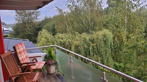 a balcony with two chairs and trees at Helle Wohnung mit Balkon 120qm, 4Zimmer in Dortmund