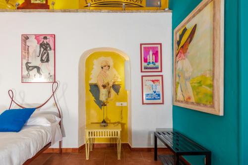 a room with a bed and paintings on the wall at Hotel Utopía in Benalup Casas Viejas