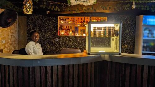 um homem sentado num bar num restaurante em Kosam Global Hotel and Suites em Uyo