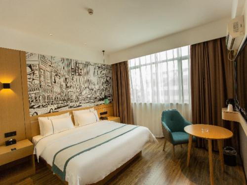 a hotel room with a bed and a chair at City Comfort Inn Shaoguan Biguiyuan Phoenix City Gold Village in Shaoguan