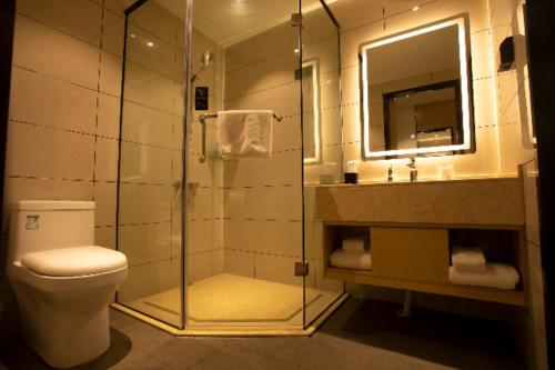 uma casa de banho com um chuveiro, um WC e um lavatório. em City Comfort Inn Huaihua East Station em Huaihua