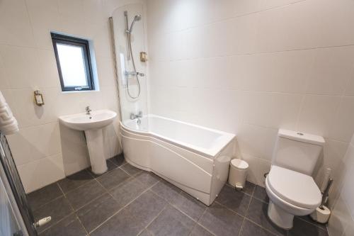 a white bathroom with a toilet and a sink at Yorkshire Dales Lodge 4 Family 3 Bed in Richmond