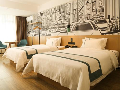 dwa łóżka w pokoju hotelowym z rysunkiem na ścianie w obiekcie City Comfort Inn Maoming Binhai New Area Diancheng 