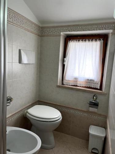 a bathroom with a toilet and a sink and a window at ''Casetta a Colonnella'' in Colonnella