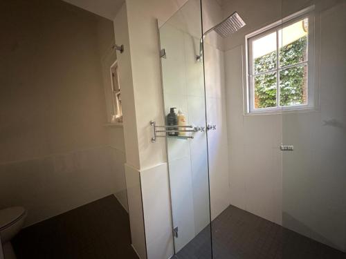 La salle de bains est pourvue d'une douche avec une porte en verre. dans l'établissement 2 Bedroom Family Friendly Ultimo Near the Centre 2 E-Bikes Included, à Sydney