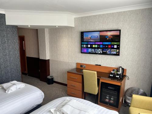 a hotel room with a bed and a tv on the wall at The Liner at Liverpool in Liverpool