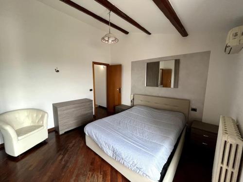 a bedroom with a white bed and a chair at ''Casetta a Colonnella'' in Colonnella
