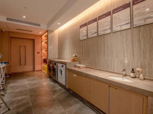 y baño con lavabo y lavadora. en GreenTree Eastern Hotel Nanning Wuxiang Hangyang City, en Nanning