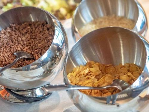 dos tazas de medición con cereales y nueces en una mesa en GreenTree Eastern Hotel Nanning Wuxiang Hangyang City, en Nanning