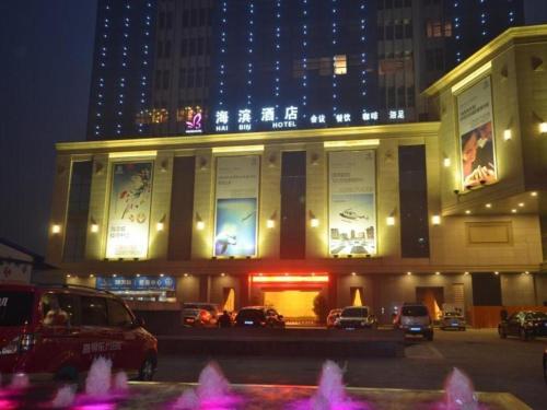 ShuangliuにあるVX Hotel Chengdu Jiaolong Port Haibinの夜間の車が停まった建物