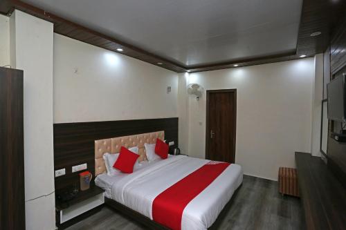 - une chambre avec un grand lit et des oreillers rouges dans l'établissement OYO The Mountain Dream, à Mussoorie