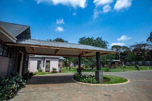 a pavilion in front of a building with a roof at Kinga Homes Boutique Hotel in Moshi