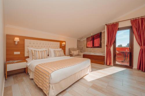 a bedroom with a large bed and a balcony at Sundia By Liberty Suncity in Oludeniz