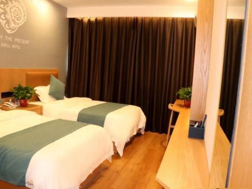 Shell Hotel Bozhou Lixin County Passenger Center في Lixin: غرفة فندقية بسريرين ونافذة