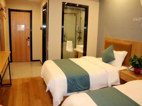 Shell Hotel Bozhou Lixin County Passenger Center في Lixin: غرفه فندقيه سريرين وحمام