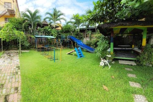 een tuin met een speeltuin met een glijbaan bij Sunny Point Hotel in Pequeno