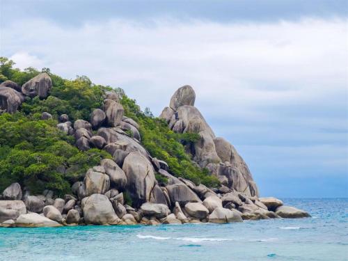 a rocky island in the ocean with blue water at Tao Island Boutique Hotel in Koh Tao