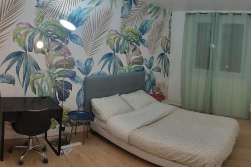 une chambre avec un lit et un bureau avec une fresque murale dans l'établissement Jolie 4 pièces, gare de train à 150 m pour aller sur Paris en 15 min, à Deuil-la-Barre