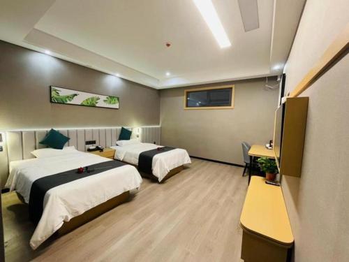 a hotel room with two beds and a flat screen tv at Thank Inn Jiangsu Suqian Sucheng District Car Town in Suqian