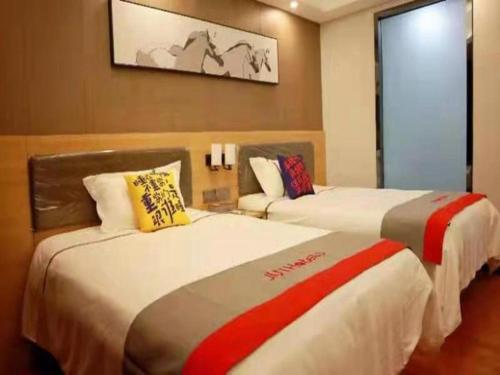 pokój hotelowy z 2 łóżkami w pokoju w obiekcie Jun Hotel Guangdong Zhanjiang Xiashan South Railway Station w mieście Zhanjiang